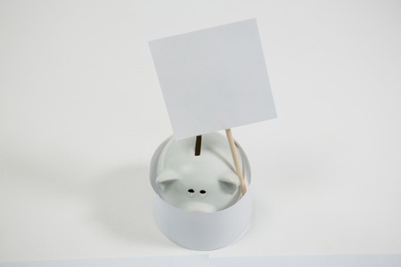 Close-up of piggy bank with placard sign boardの写真素材