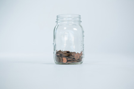 Coins in glass jars on white backgroundの写真素材