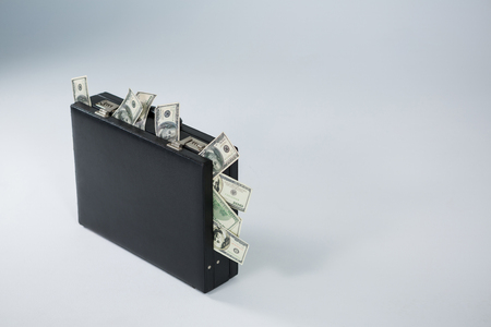 Bank notes coming out of briefcase on white background