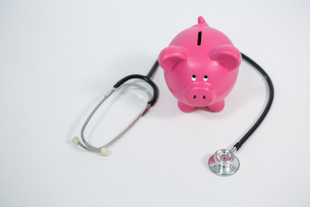Piggy bank and stethoscope on white backgroundの写真素材
