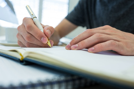 Close-up of graphic designer working at his desk in office