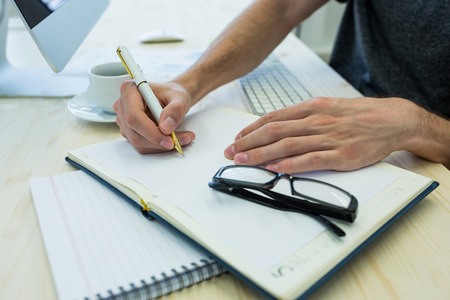 Close-up of graphic designer working at his desk in officeの写真素材