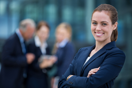 Portrait of smiling businesswoman standing with arms crossedの写真素材