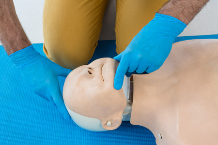 Mid section of paramedic practising resuscitation in clinic