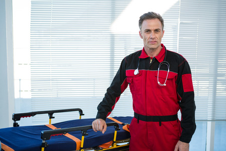 Portrait of paramedic standing beside a stretcher in clinicの写真素材