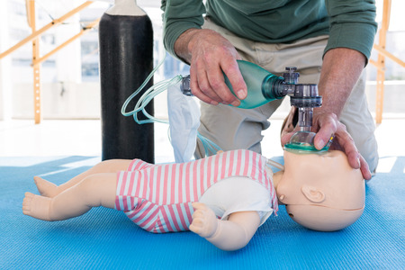 Paramedic practicing resuscitation on dummy in clinicの写真素材