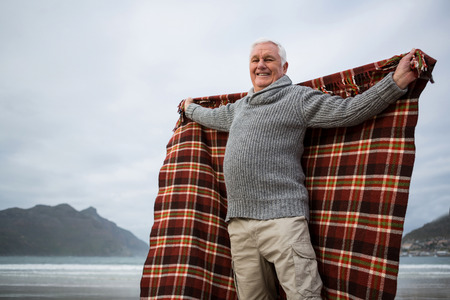 Happy senior man enjoying on beachの写真素材