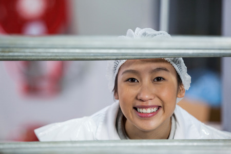 Portrait of female butcher standing in meat factoryの写真素材