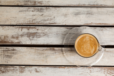 Overhead view of cup of coffee on wooden tableの写真素材