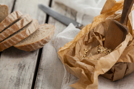 Sliced loaf of bread with knife on wooden backgroundの写真素材