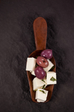 Cheese cubes with herbs on chopping boardの写真素材