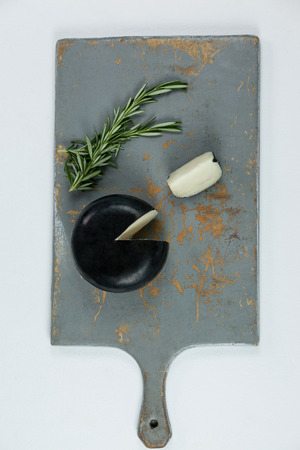 Close-up of sliced cheese and rosemary on chopping boardの写真素材