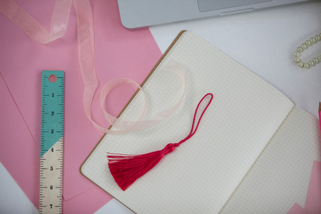 Diary, bookmark, ruler, ribbon and laptop on deskの写真素材