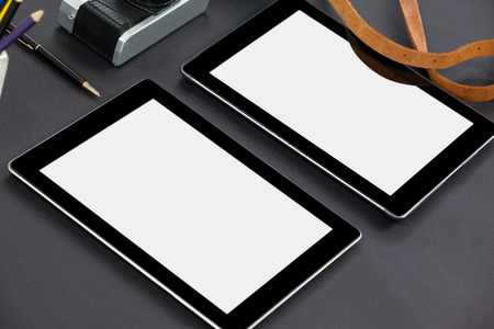Digital tablets, camera and belt on grey backgroundの写真素材