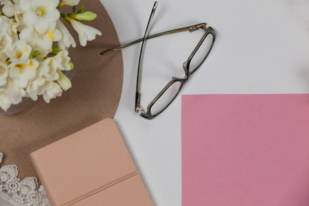 Spectacles, diary, blank page and flowers on white backgroundの写真素材
