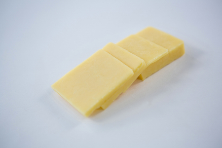 Close-up of slices of cheese on white backgroundの写真素材