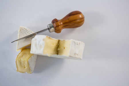 Piece of cheese with knife on white backgroundの写真素材