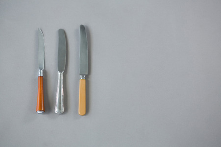 Variety of spread knife against grey backgroundの写真素材