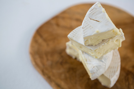 Brie cheese on wooden board against white backgroundの写真素材