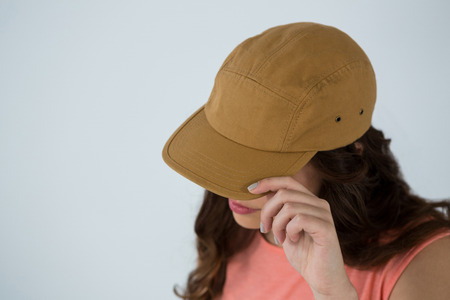 Woman in brown cap against white backgroundの写真素材