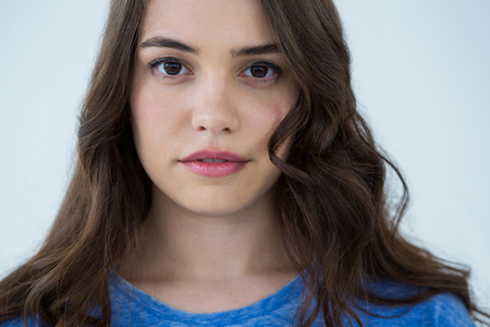 Portrait of a beautiful woman in blue top against white background