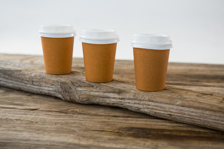 Close-up of disposable coffee cups arranged on wooden plankの写真素材