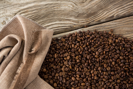 Close-up of coffee beans in sack on wooden tableの写真素材