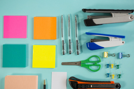 Various office supplies on turquoise background