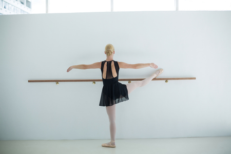 Rear view of ballerina practicing ballet dance in the studioの写真素材