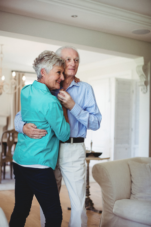 Senior couple dancing together in living room at homeの写真素材