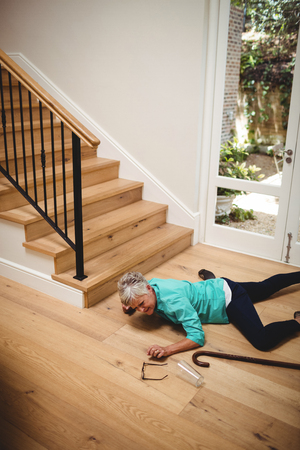 Senior woman fallen down from stairs at homeの写真素材