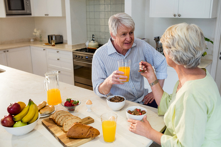 Senior couple having breakfast together at homeの写真素材