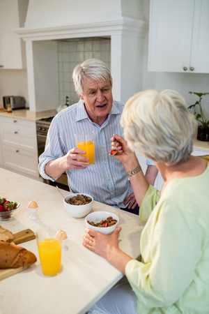 Senior couple having breakfast together at homeの写真素材
