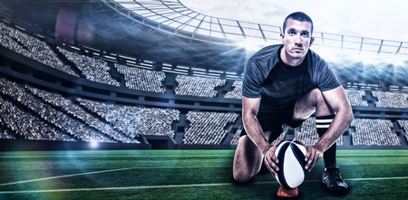 Portrait of rugby player in black jersey placing ball against rugby stadium with copy space 3dの写真素材