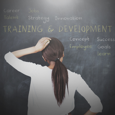 Attractive woman looking at a chalkboard with business terms written on itの写真素材