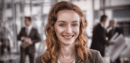 Portrait of smiling pretty businesswoman standing in office