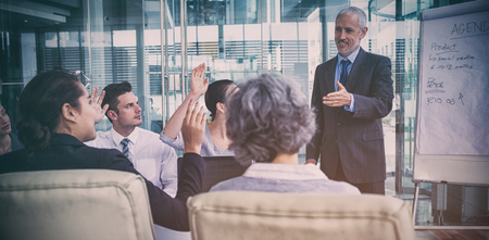 Businessman interacting with coworkers during meeting in officeの写真素材