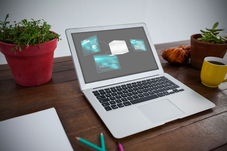 Technology interface  against laptop with coffee mug and pot plant in wooden tableの写真素材