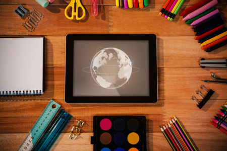 Global technology background against digital tablet with various stationery with copy spaceの写真素材