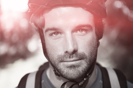 Portrait of male mountain biker in forest on sunny dayの写真素材