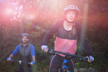 Smiling biker couple cycling in countrysideの写真素材
