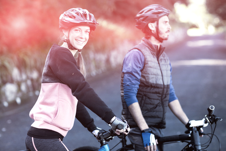 Biker couple with mountain bike on countryside roadの写真素材