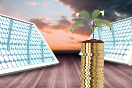 Stack of gold coins and plant in soil against orange and blue sky with clouds 3dの写真素材