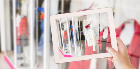 Masculine hand holding tablet against shops in shopping mallの写真素材