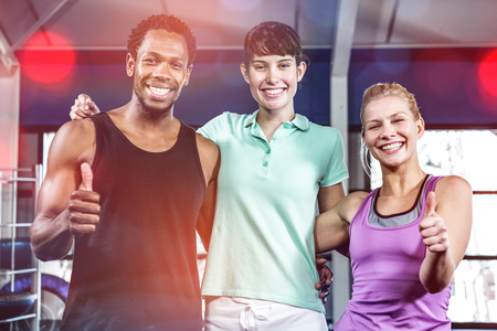 Muscular smiling people standing together in gymの写真素材