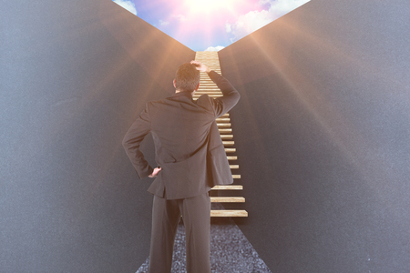 Businessman standing back to the camera with hand on head against grey 3dの写真素材