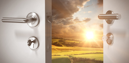 Closeup of wooden door with metallic doorknob against country scene