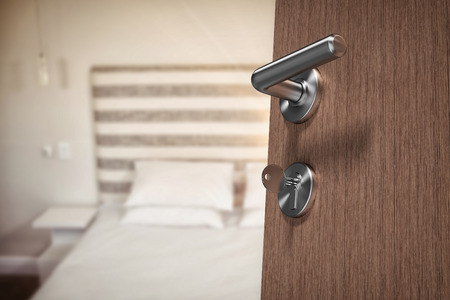 Low angle view of brown door with key against bedroomの写真素材