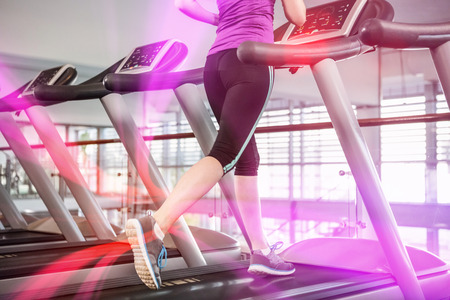 Lower section of fit woman on treadmill at gymの写真素材