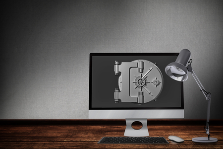 Computer by table lamp against digitally generated grey backgroundの写真素材